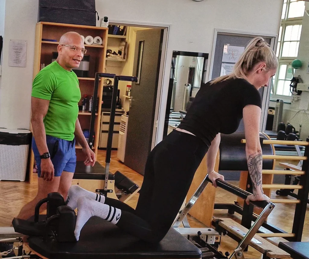 Teejay Sogunro teaching a client on the Reformer at Applied Pilates, London Colney, St Albans